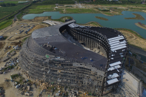 Ein Geb%C3%A4ude, ein Gew%C3%A4sser mit Gras drumherum und ein Auto.