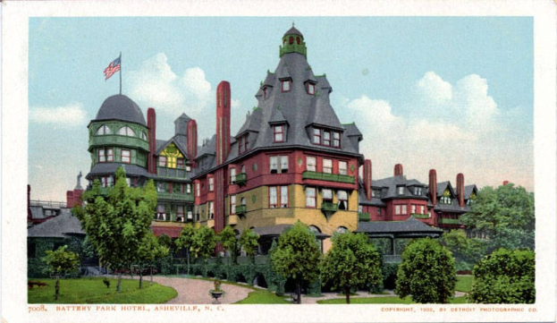 Schwarz-weiß-Postkarte des Battery Park Hotels in Asheville, North Carolina, zeigt ein großes Gebäude mit einer Fahne oben drauf, umgeben von Bäumen, Pflanzen, Gras und einem Weg, mit Himmel im Hintergrund und Text unten.