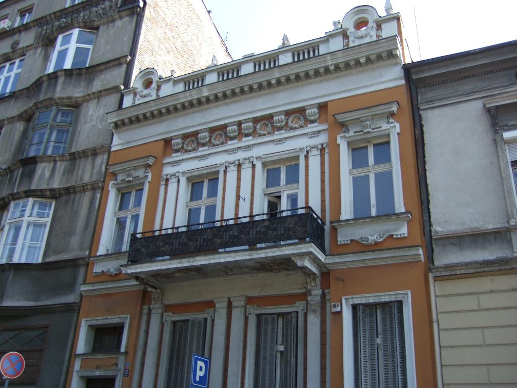 Gebäude mit Türen und Fenstern, Vorsichtsplatten an Masten, bei klarem Himmel.