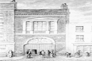 Eine Zeichnung eines Gebäudes mit Fenstern und einer Tür, mit einer Gruppe von Menschen davorstehend, und einem Text unten lesend "1892 - die erste Feuerwache".