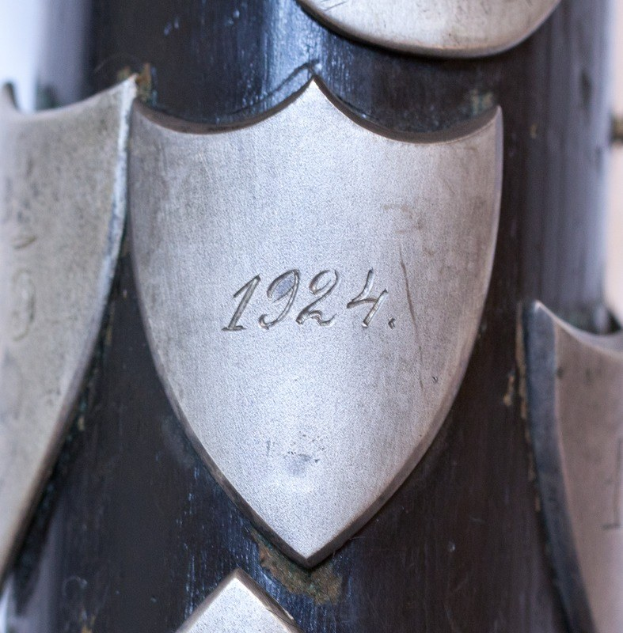 Nahaufnahme eines metallischen Gegenstands mit einer eingravierten Zahl, ähnlich einer Feuerwaffe.