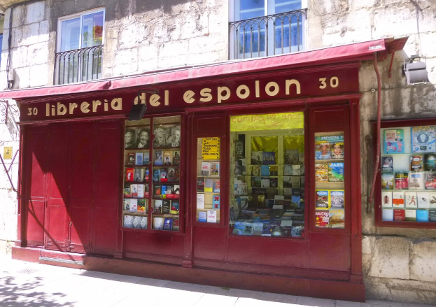 Eine Buchhandlung mit rotem Markisen namens "Libreria del Espolon" mit ordentlich sortierten Büchern im Schaufenster