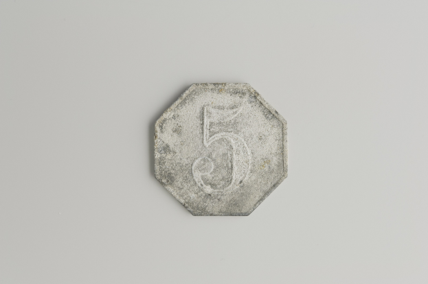 Eine 5-Cent-Münze mit der Zahl fünf auf einer weißen Oberfläche.