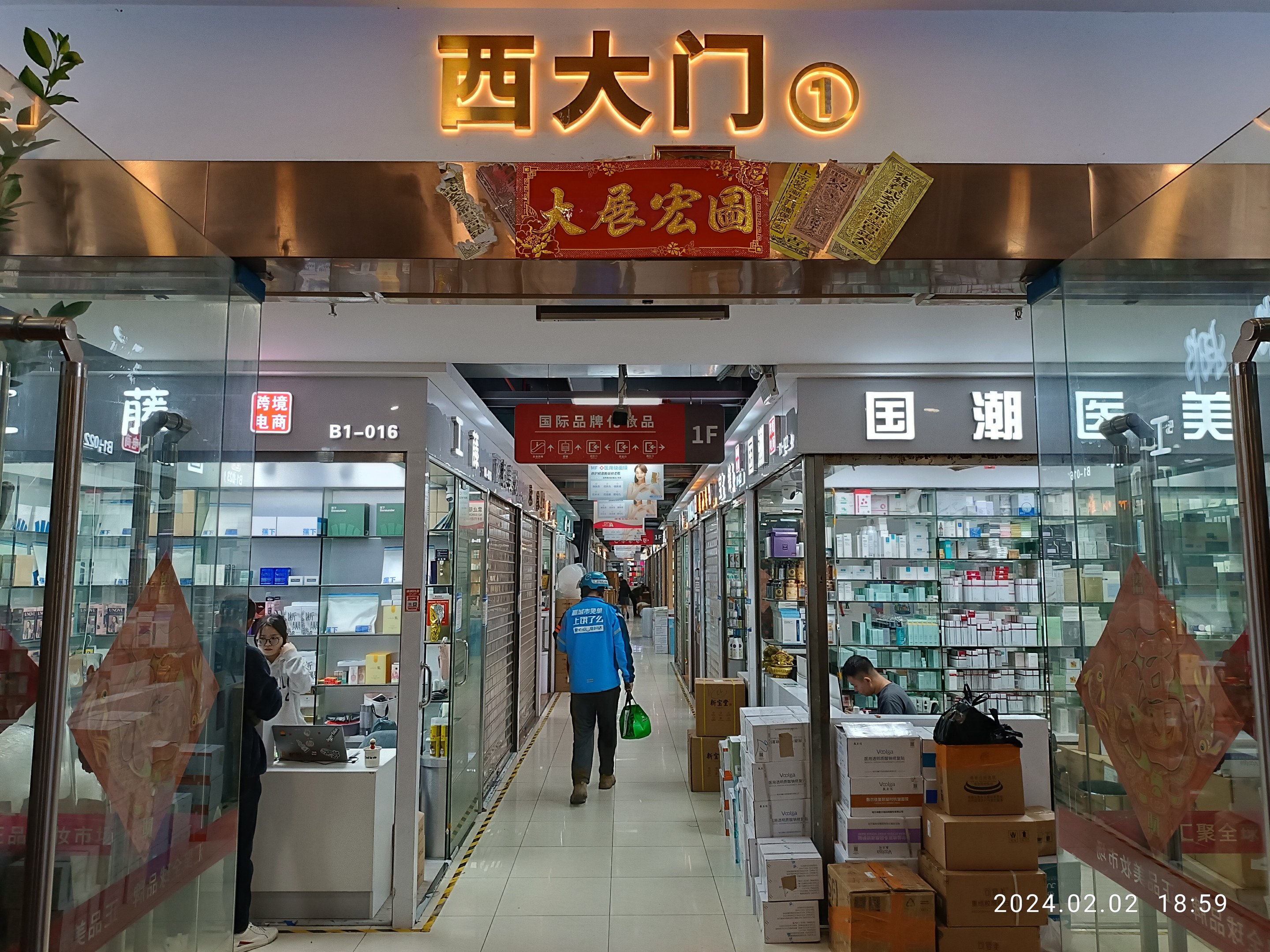 Innenraum einer chinesischen Apotheke mit Glaswänden, Regalen voller Artikel, verstreuten Kartons, einer Pflanze auf der linken Seite und einem Namensschild oben, das darauf hinweist, dass es sich um eine chinesische Drogerie handelt.