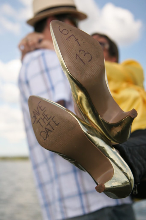 Frau in High Heels mit Datumsangaben auf den Absätzen, mit einer Person, die eine Frau von hinten hält.