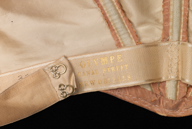Ein Detailbild eines hellen Stoffs mit einer Beschriftung, die "Gürtel" lautet.