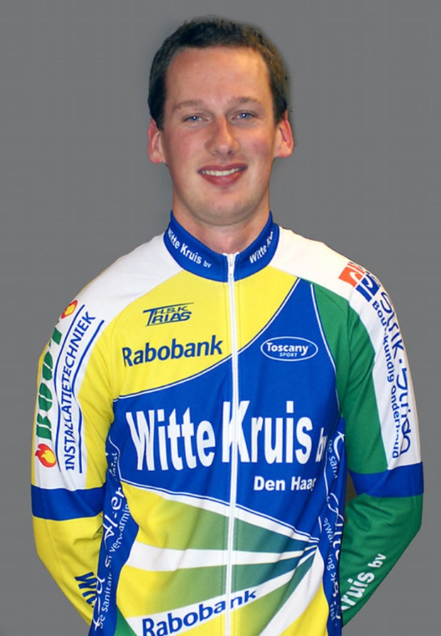 Ein Sportler posiert für ein Foto mit Namen von Sponsorenunternehmen auf seinem Hemd.