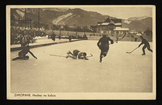 Ein altes Schwarz-Weiß-Foto von Menschen, die Hockey auf einem Eisring spielen, umgeben von Gebäuden, Bäumen, Pfählen und Bergen im Hintergrund, mit Text unten.