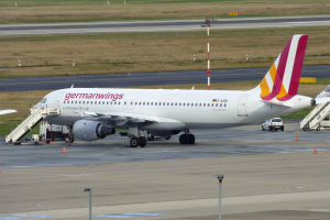 Airbus A320-200 der Germanwings am Frankfurter Flughafen geparkt mit Bodenfahrzeugen, Verkehrskegeln, Pfählen und Gras im Hintergrund.