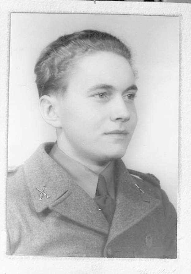 Schwarzes und weißes Foto einer Frau in militärischer Uniform mit ernstem Gesichtsausdruck, die einen Blazer und eine Krawatte trägt, das Haar ordentlich hochgesteckt, konzentrierte Augen und eine selbstbewusste Haltung.