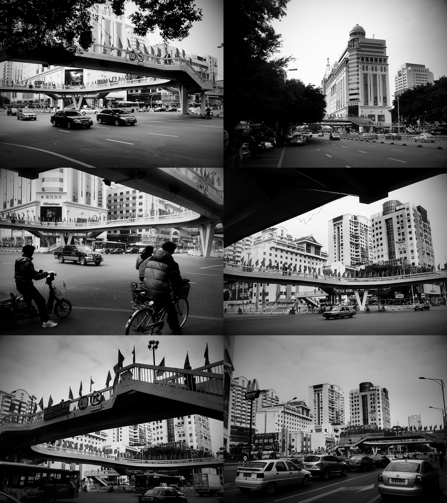 Autos und Fahrräder werden unter einer Brücke gesehen, mit ein paar Fahrzeugen vor einem Gebäude.