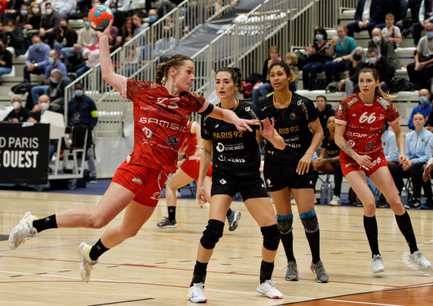 Eine Gruppe von Frauen beim Handballspielen auf einem Feld während der Handball-Weltmeisterschaft 2019 in Paris, mit Zuschauern im Hintergrund und einer Anzeigetafel, die "Frankreich vs. Frankreich" anzeigt.