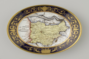 Ein dekorativer Teller mit einer Karte von Polen, mit detailreichen Verzierungen, auf einem weißen Hintergrund.